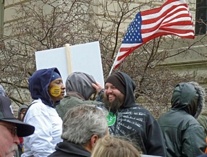 Flag waving in the breeze over protesters